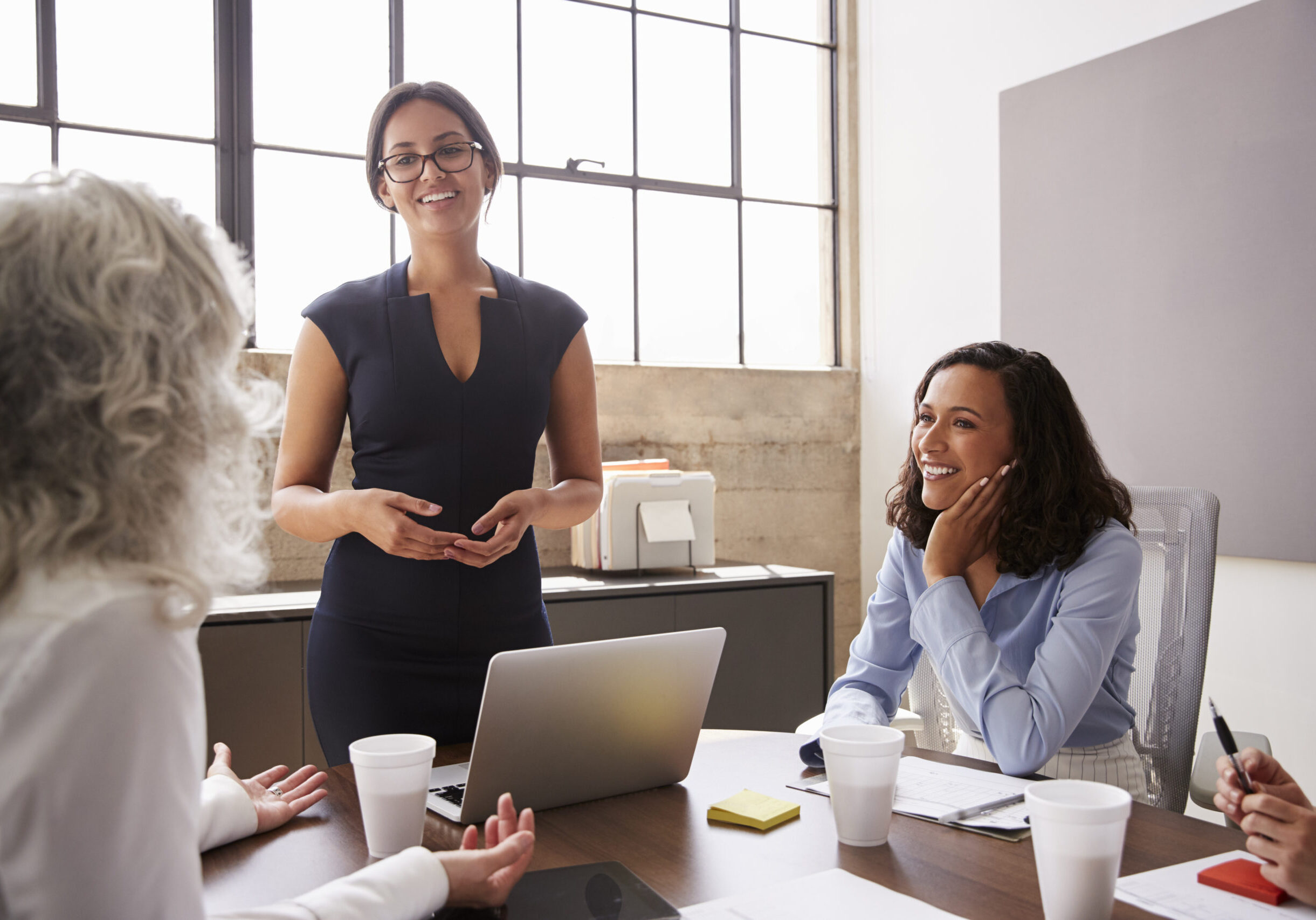 Woman presenting to colleagues during a meeting